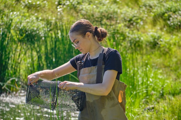 Student in waders working outside