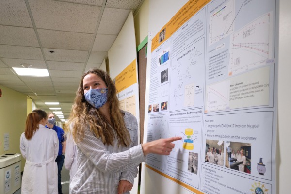 Student showing her research on poster