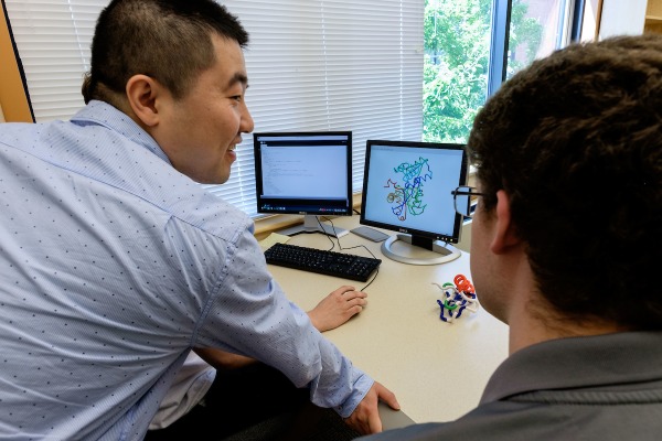 Student working with Professor Cao on laptop