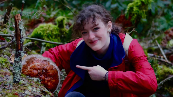 Fiona hold a fungus in the forest