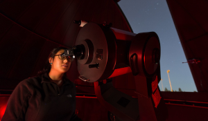 student looking through telescope