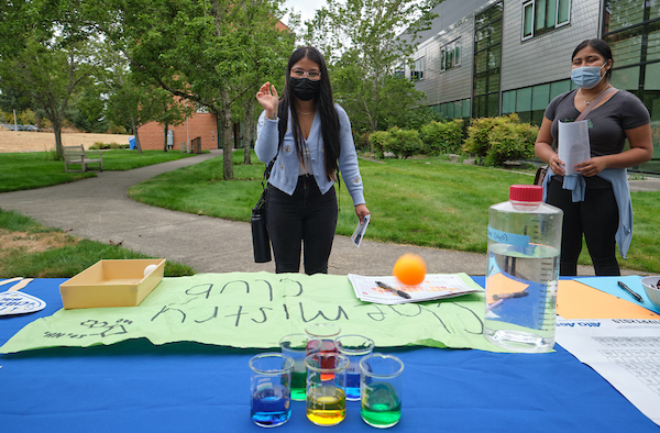 student throwing ball into beakers