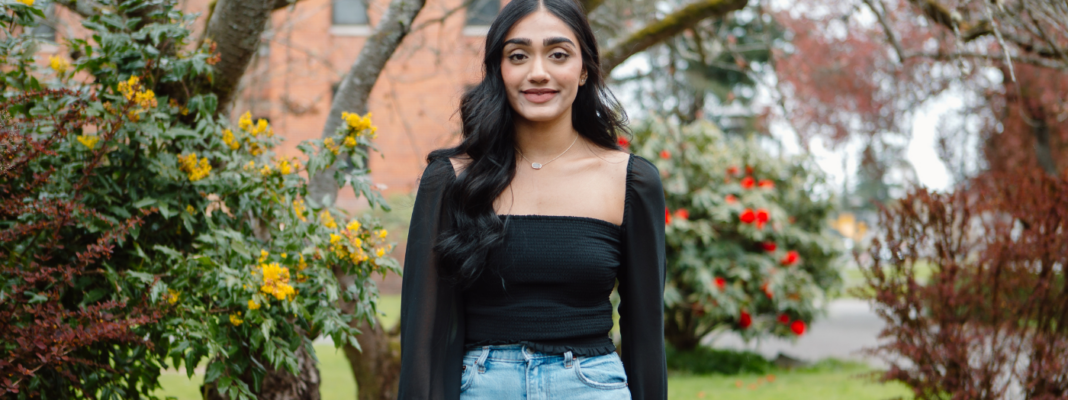 Jasneet Sandhu standing outside on campus.