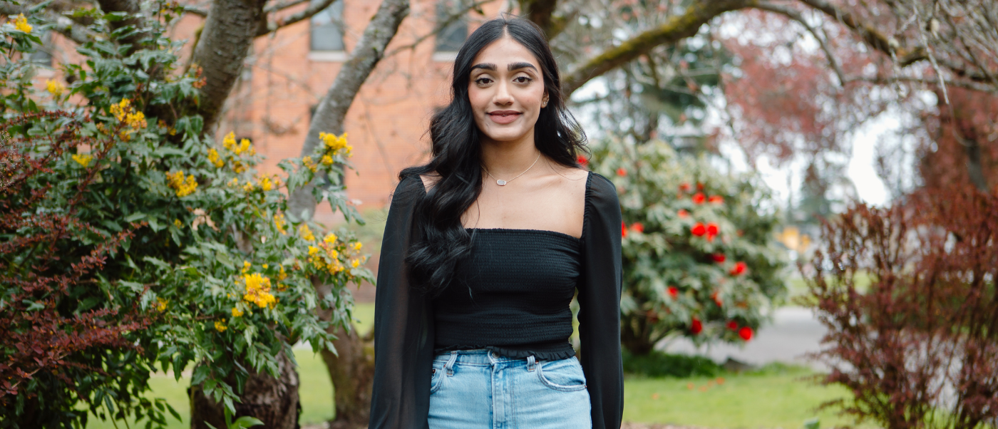 Jasneet Sandhu standing outside on campus.