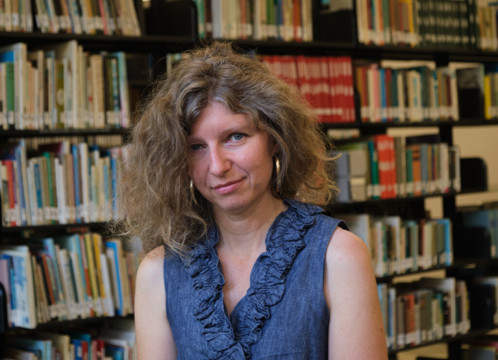 Rebecca Wilkin in front of a bookshelf.