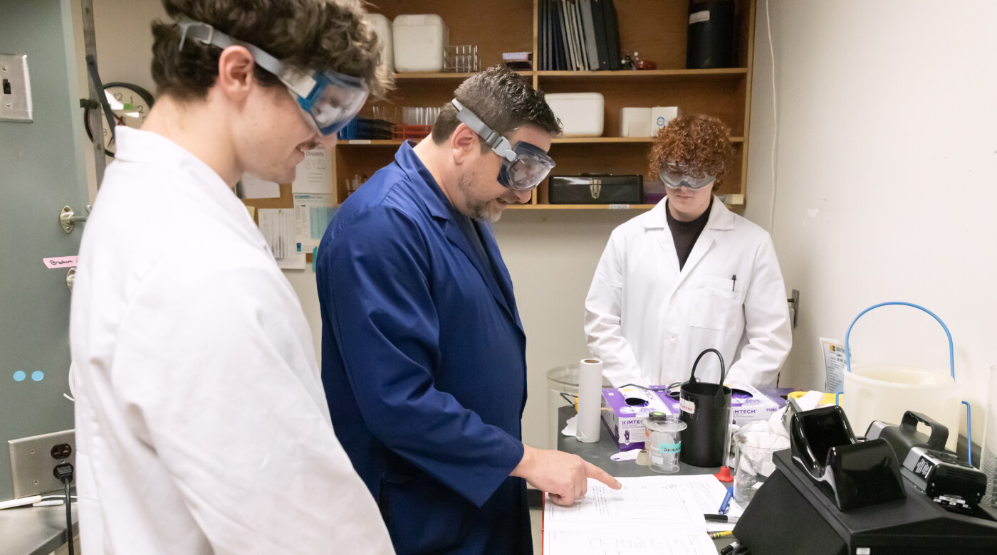 Professor Yakelis and research students work in lab.