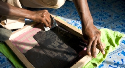 Person adding screenprint to a tee shirt