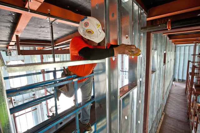 Renovations on Eastvold Auditorium continue, here a construction worker is working on a metal wall