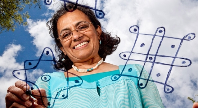 PLU Associate Professor Vidya Thirumurthy draws a kolam, an artful design that Hindu households use to communicate with their community. (Photo by John Froschauer)