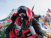 Gary Nelson stands in front of a prayer flag monument on Mt. Everest.