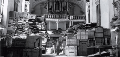 A lone US soldier guards plunder stolen by Nazis that was hidden in a German church. (Photo courtesy of National Archives)