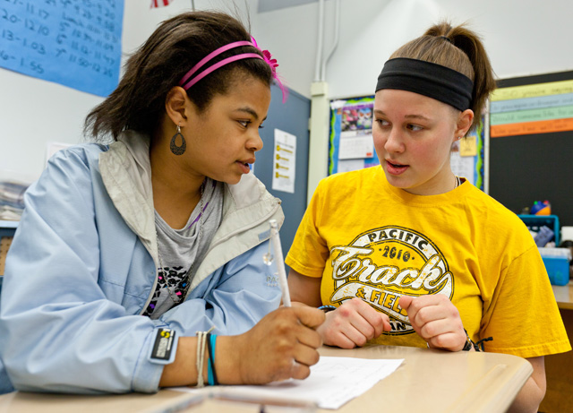 Melissa Castor ’14 helps a sixth grade student at Keithley Middle School with her math work. (Photos by John Froschauer)