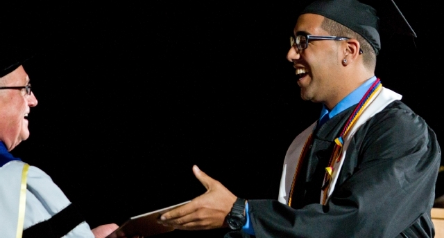 PLU President Loren J . Anderson congratulates Mycall Ford ’12 at the Spring Commencement in the Tacoma Dome on Sunday.