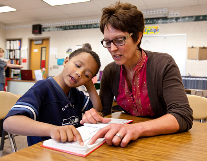 Nancy Herold ’76 works with a student on their reading.