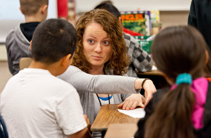 Rosa Bushey '10, '11 works with students on an assignment.