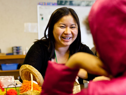 Ruthy (Eap) Green ’06 helps a student with her lunch.