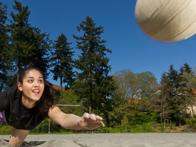 Allison McClure diving for a volleyball in the sand