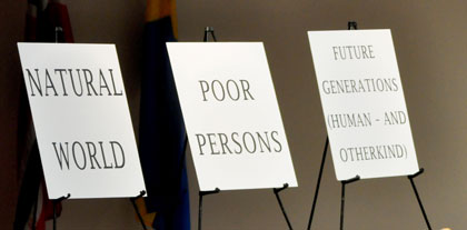 Three chairs with signs representing the un-represented and the under-represented of Earth. Natural World, Poor Persons, Future Generations Human - And Otherkind