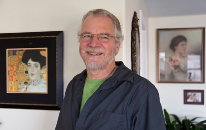 Peter Atlmann stands in front of a miniature of the Klimt painting of his great aunt, while behind him is a portrait of his grandmother. (Photo by John Froschauer)