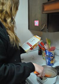 Gordon checks the step-by-step instructions on the back of her box of Hamburger Helper to make sure she doesn’t overcook her noodles.
