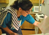 Ashley Dell’Osa ’13 reaches into her fridge to grab some salad fixings.