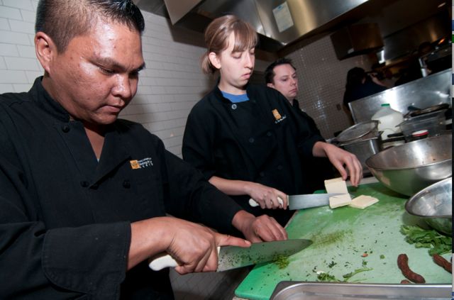 Elizabeth Herzfeldt-Kamprath ’12 works alongside Dining and Culinary staff during the annual Commons on Fire cooking competition.