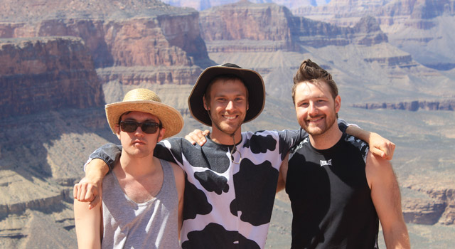 Three students standing in front of the Grand Canyon