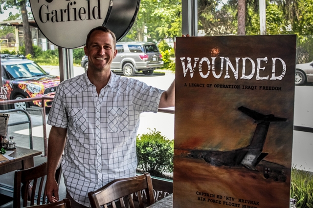 Ed Hrivnak ’96 with a poster of his new book “Wounded,” which tells of his experiences in the Iraq War. (Photo by Quinn Huelsbeck ’16)