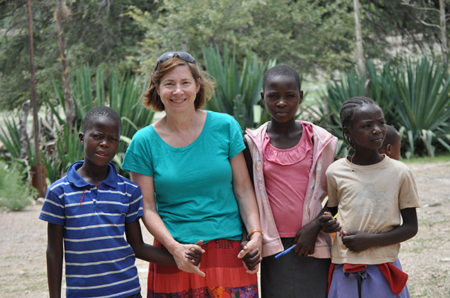 Group picture of Jan Weiss in Namibia holding young peoples hands