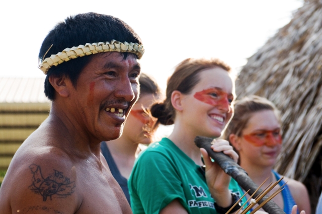 PLU students Karyssa Allbritton and Kristin Neuneker get a lesson in blowgun use from Bolivar Endominga in Ecuador on a 2012 Study Away program. (Photo by Kyle Monahan.)