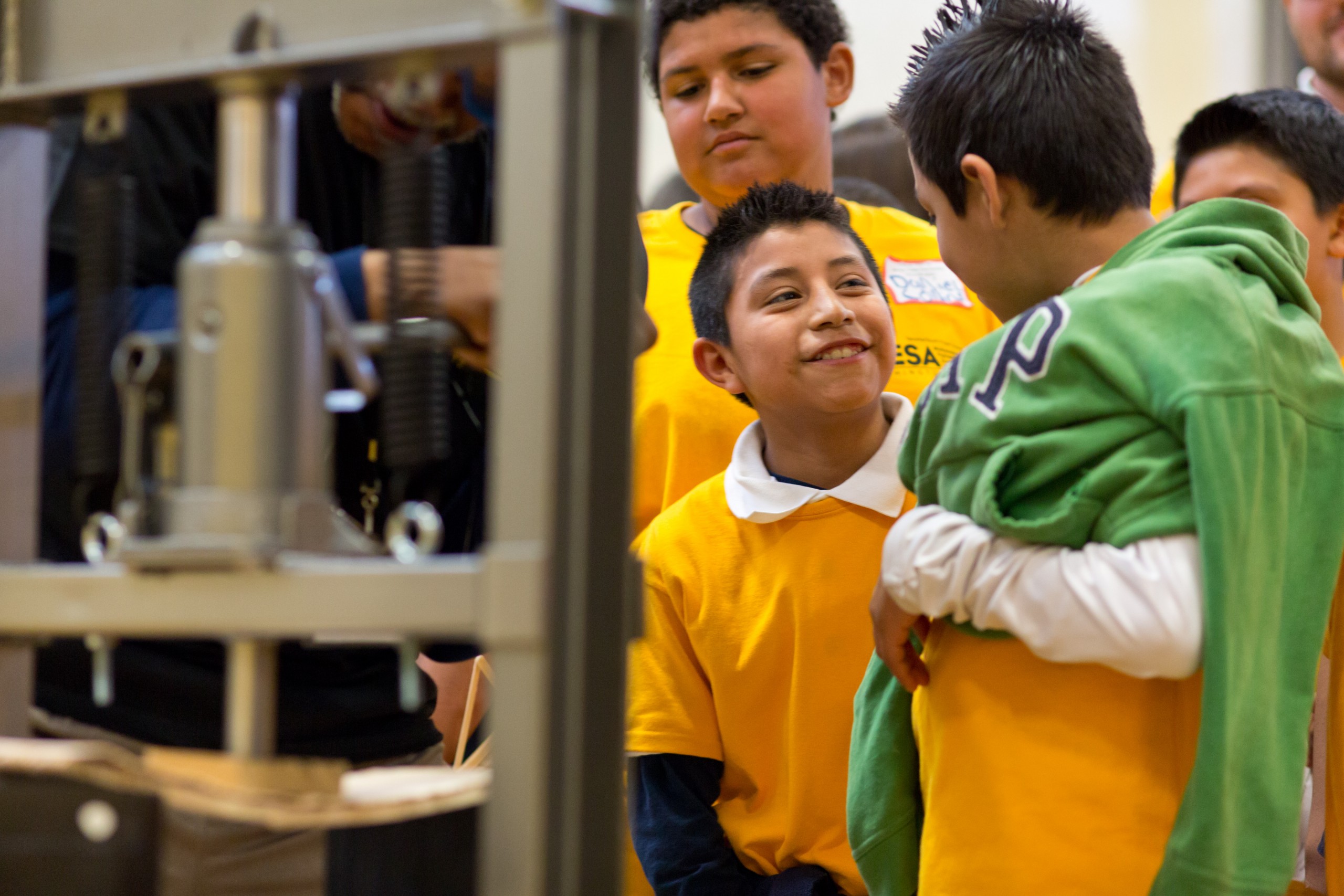 Denner Galindo, left, smiles at his teammate Antonio Reyes as the boys’ stick bridge is tested at PLU’s MESA Day event March 25. (Photo: John Froschauer / PLU)