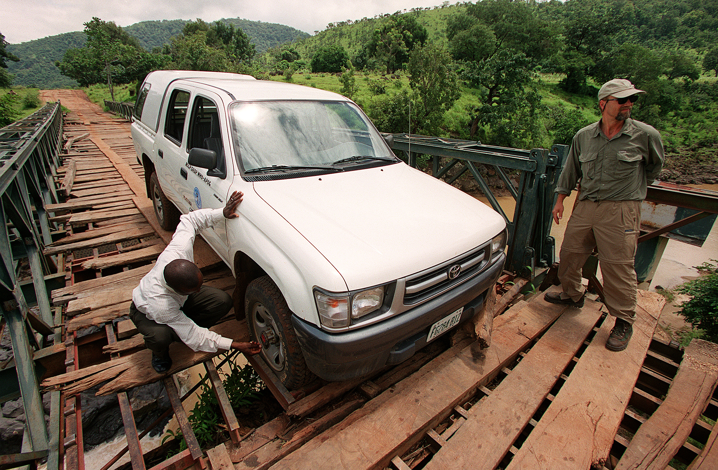 In 2001, Paulson traveled to Nigeria to report on the beginnings of the Bill and Melinda Gates Foundation’s work on global health. Paulson says the planking broke on this bridge outside Jos, Nigeria, and the driver inspected the tires because the truck wouldn’t move. “We eventually enlisted some locals to help us lift it up and get going again,” Paulson says. (Photo: Mike Urban)
