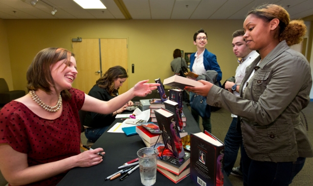 Marissa Meyer ’04 signs one of her latest books in the Luna series, ‘Scarlett’, for a fan this spring at PLU. (Photo: John Froschauer/PLU)
