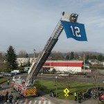 Ladder Firetruck holding up 12th man flag
