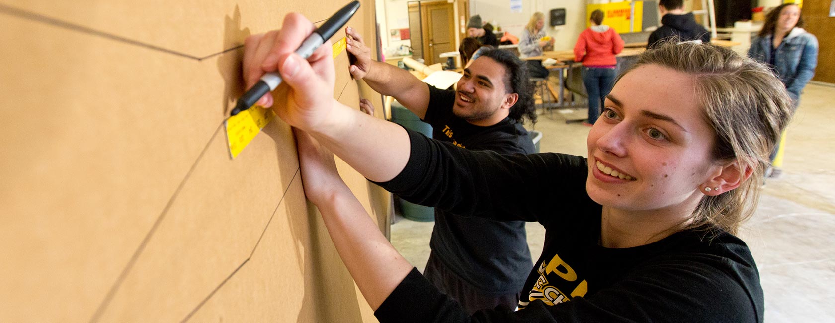 Two art students working on a wall