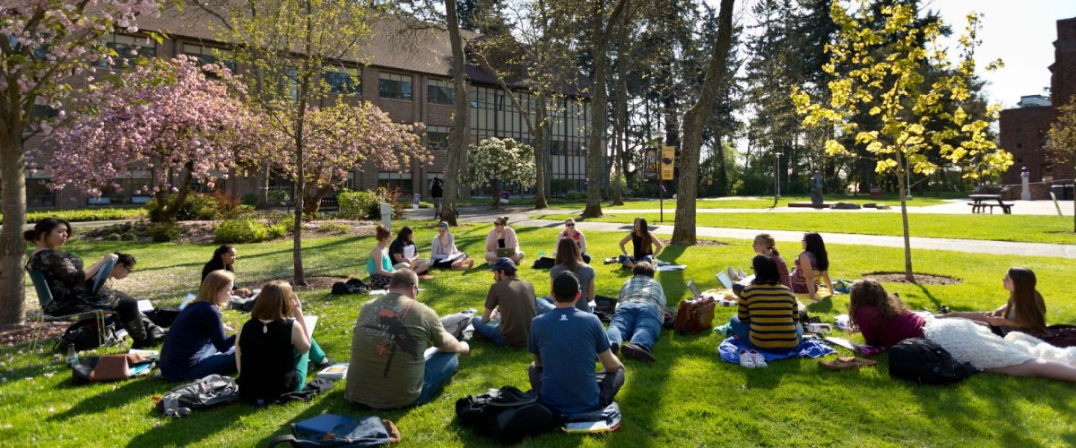 Students having class outside on a warm spring day.
