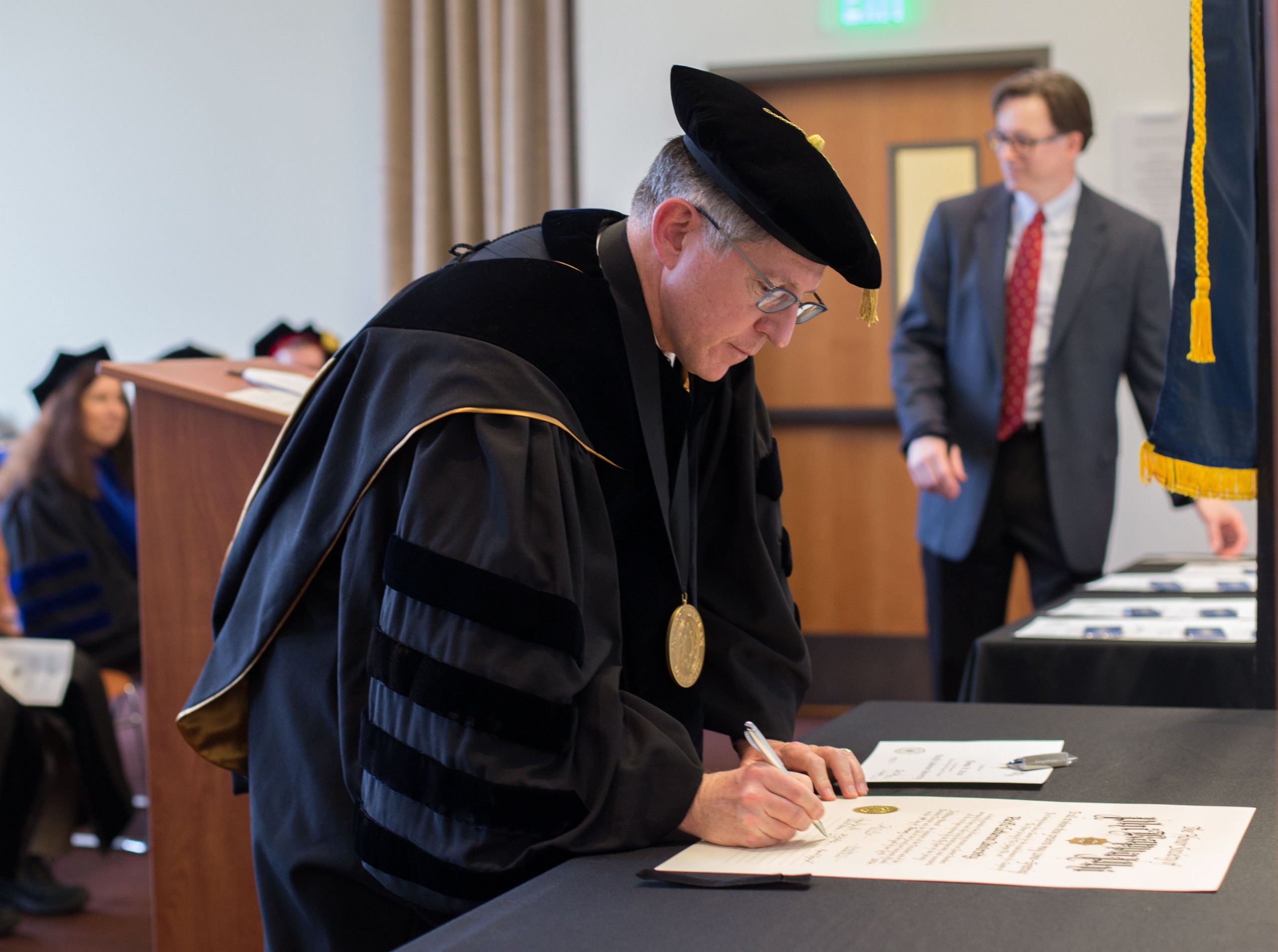 Phi Kappa Phi Chapter instillation ceremony at PLU on Friday, Feb. 19, 2016. (Photo: John Froschauer/PLU) President Tom Krise signing the chapters charter.