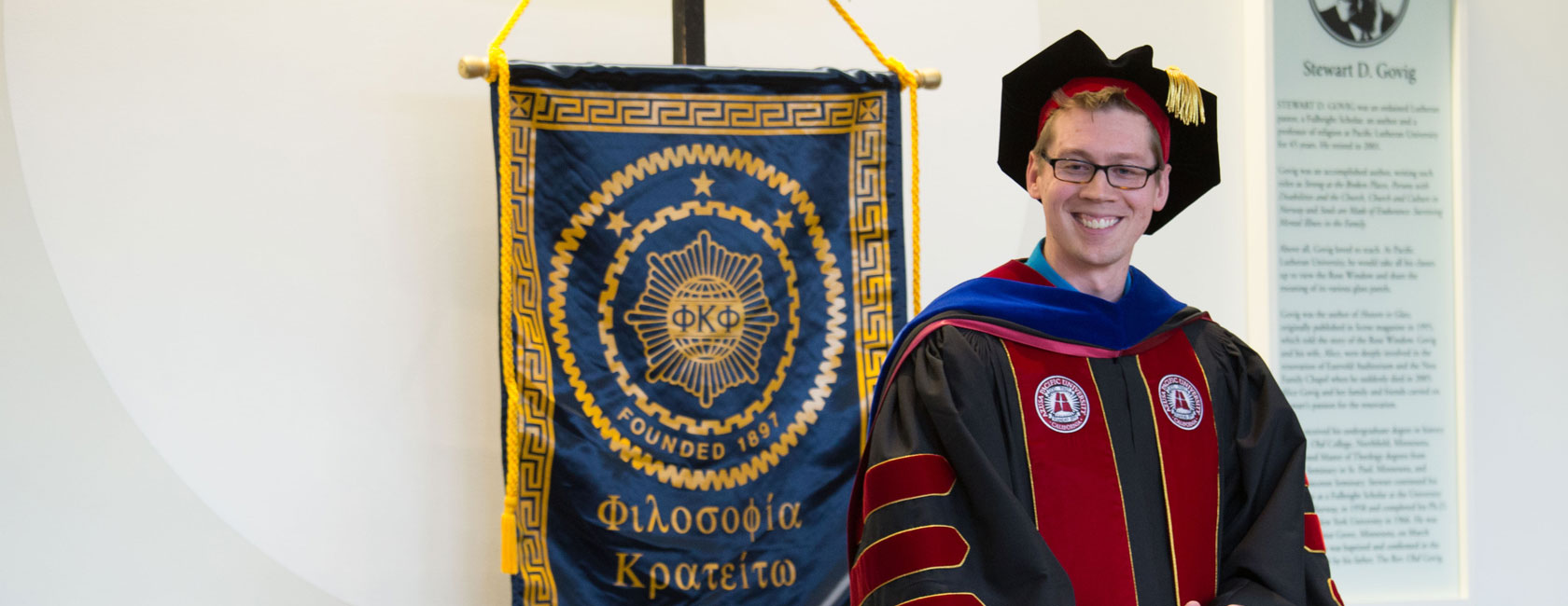 Phi Kappa Phi Chapter instillation ceremony at PLU on Friday, Feb. 19, 2016. (Photo: John Froschauer/PLU) Director of Academic Advising with the banner.