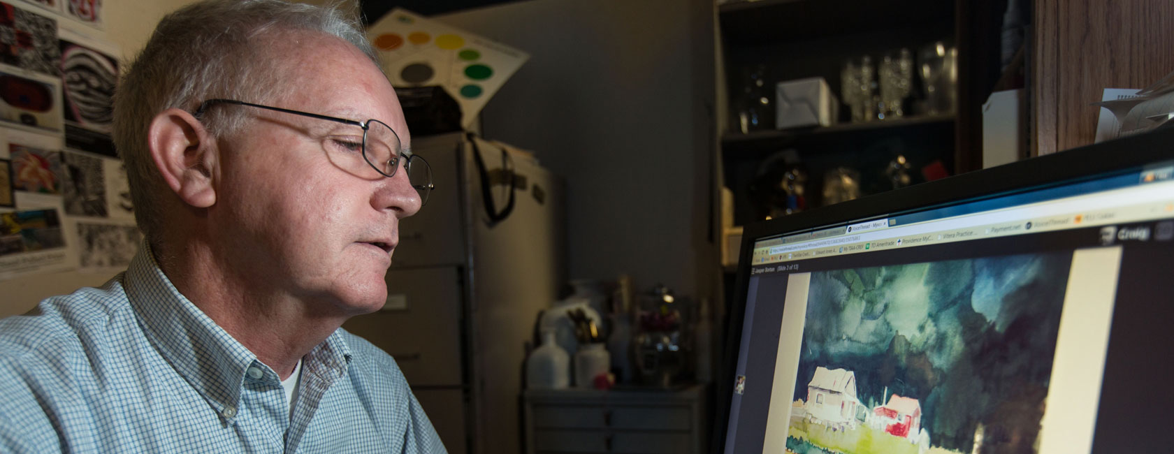 Craig Cornwall reviewing watercolor paintings for his PLUTO online class at PLU on Monday, March 9, 2015. (Photo/John Froschauer)