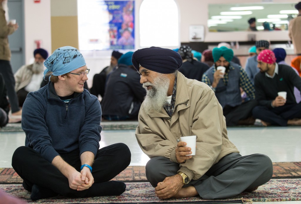 Chris Boettcher (left) takes up the class challenge to participate by asking questions of gurdwara community members.