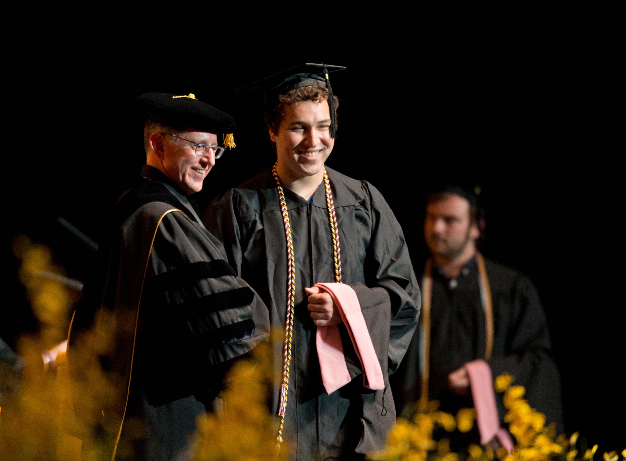 PLU President Thomas W. Krise greets a new graduate on stage at PLU's 2015 Commencement ceremony.