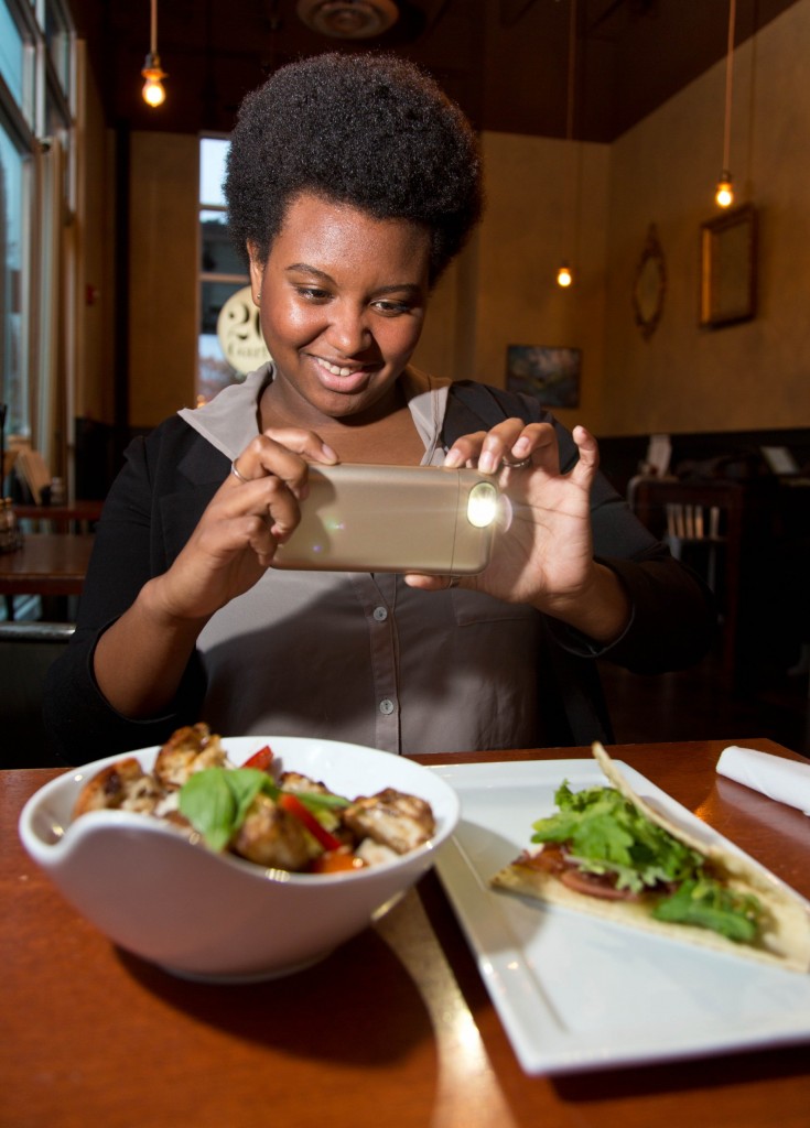 Brooke Thames snaps a photo of her lunch using her iphone.