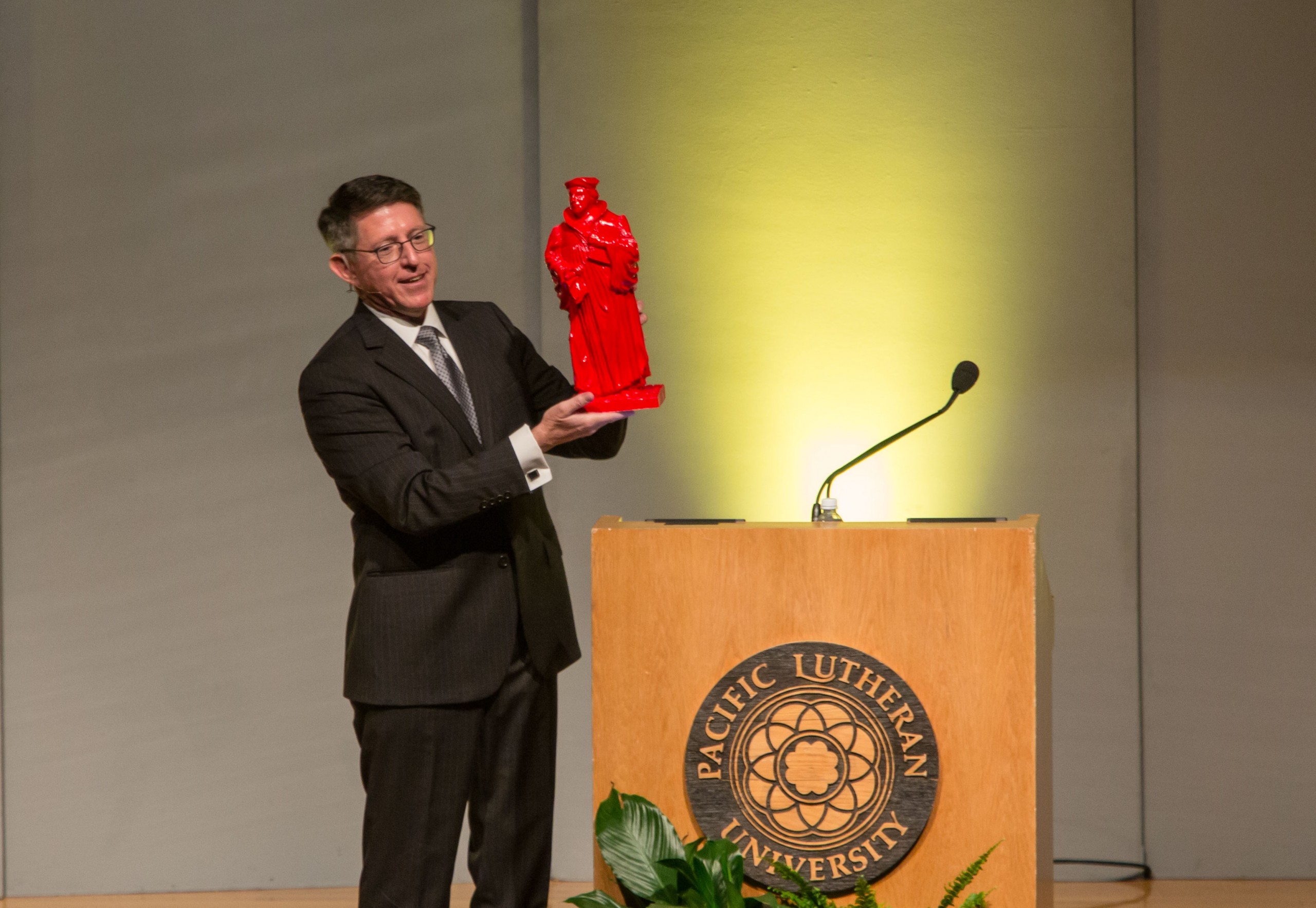 PLU President Thomas W. Krise speaks at University Conference on Wednesday, Aug. 31, unveiling one of the 21 Martin Luther statues that will be hidden around campus in October as part of the Re•forming series marking the 500th anniversary of the Reformation. (Photo: John Froschauer/PLU)