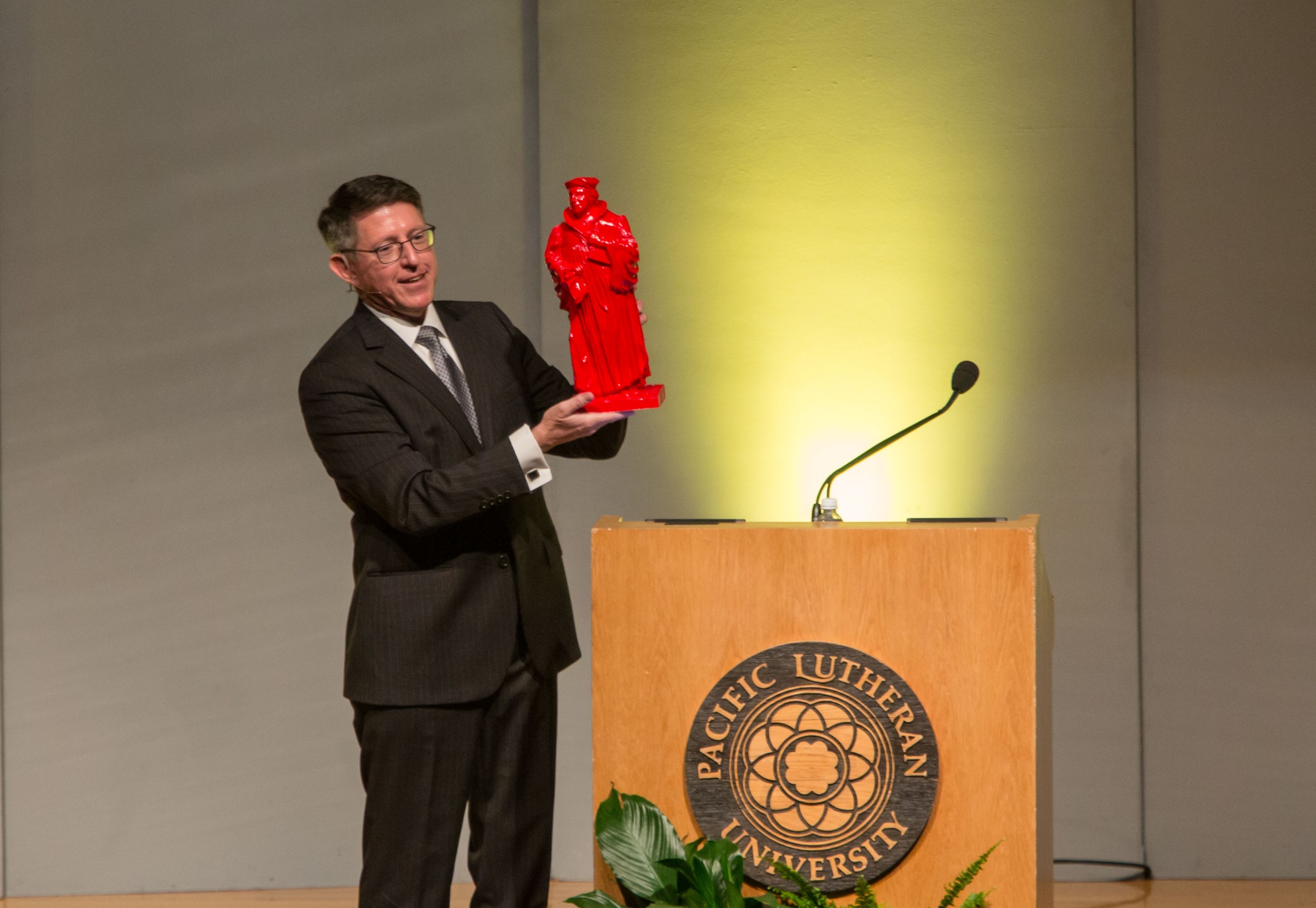 fall-conference-8-31-16-298 PLU President Thomas W. Krise speaks at University Conference on Wednesday, Aug. 31, unveiling one of the 21 Martin Luther statues that will be hidden around campus in October as part of the Re•forming series marking the 500th anniversary of the Reformation. (Photo: John Froschauer/PLU)