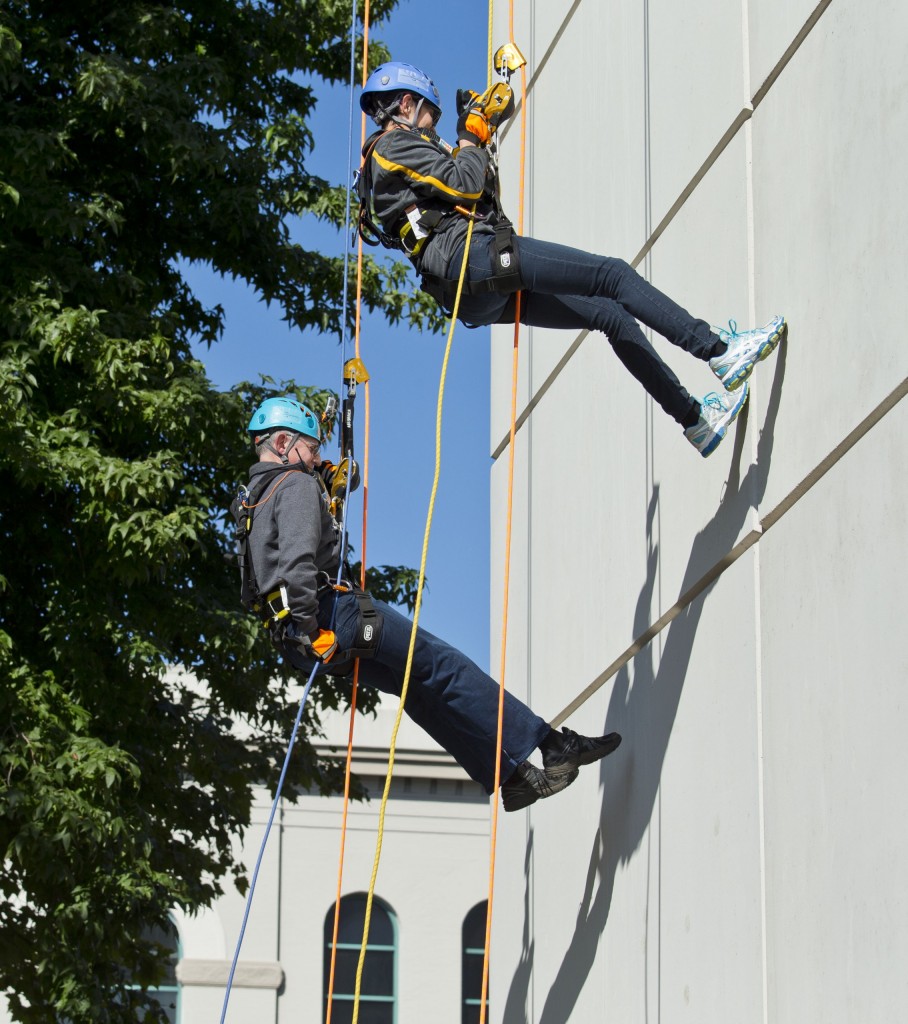 President Tom Krise and his wife, Patty, rappel down the Hotel Murano on Friday, Sept. 30, in downtown Tacoma as part of the Habitat Challenge, a fundraiser for the local Habitat for Humanity. (Photo: John Froschauer/PLU)