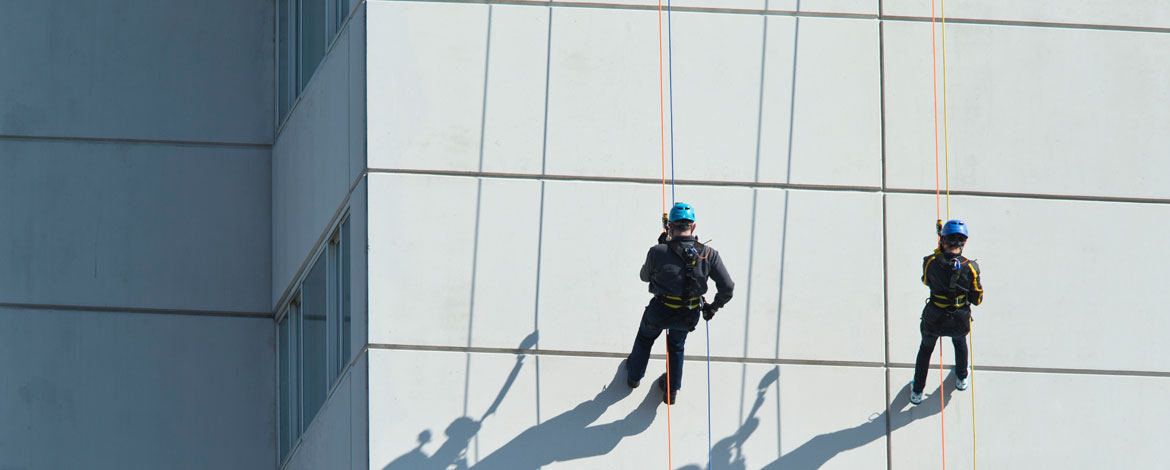 President Tom Krise (left) and his wife, Patty, rappel down the Hotel Murano in downtown Tacoma as part of the Habitat Challenge. (Photo by John Froschauer/PLU)