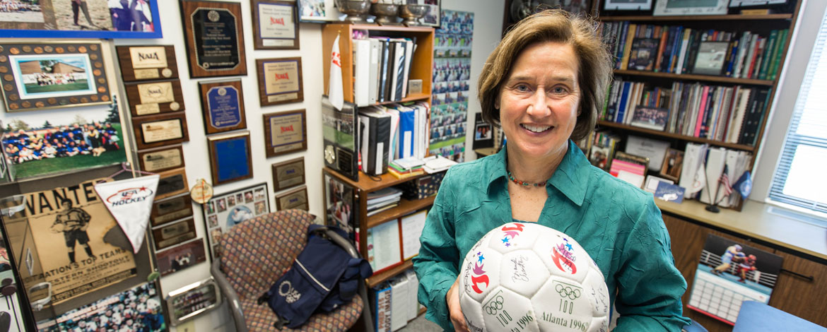 Colleen Hacker, Ph.D., stands in front of her wall of fame in her office at Pacific Lutheran University. (Photo by John Froschauer/PLU)