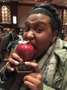Brooke Thames jokingly bites into the apple award