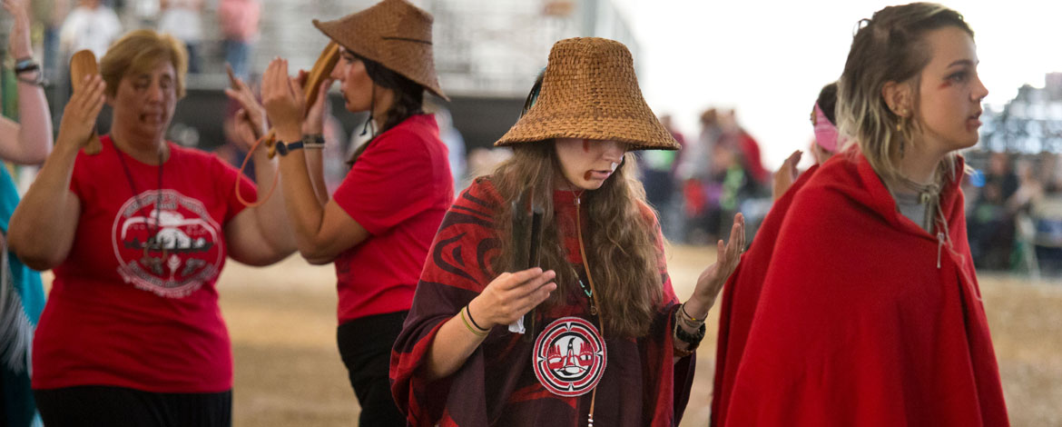 Kelly Hall '16 dances with the Samish tribe during their protocol at the annual canoe journey, hosted by the Puyallup Tribe of Indians. (Photo by John Froschauer/PLU)