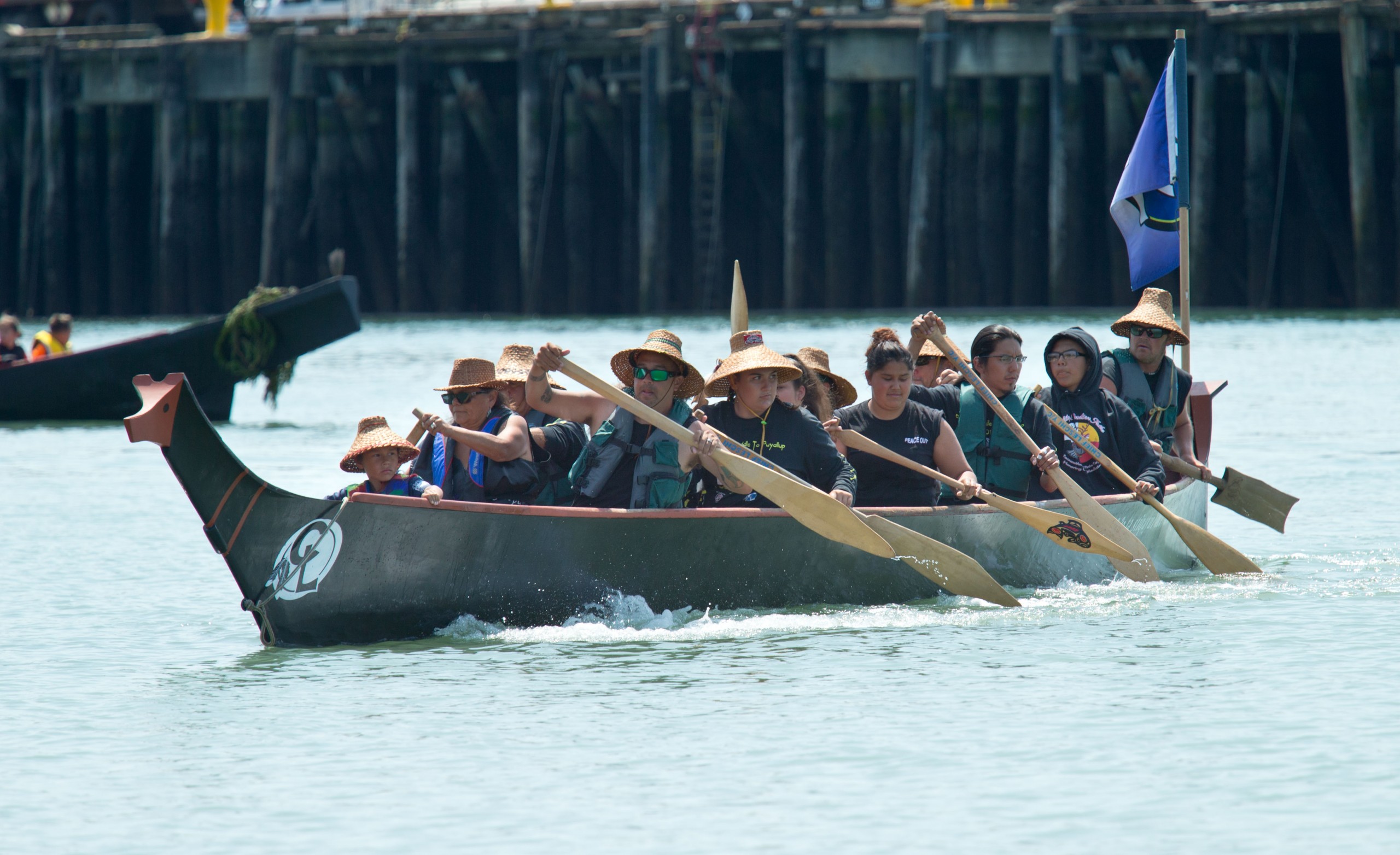 Puyallup (Chief Leschi) tribal members row to shore in their canoe, Spirit of the Wolf Protects, on Saturday, July 28. (Photo by John Froschauer/PLU)
